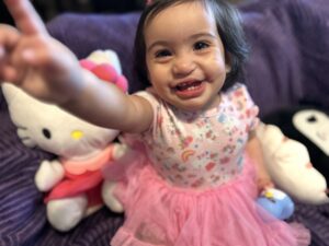 Emarosa smiling in a dress with a pink skirt.