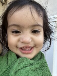 Emarosa smiling and wrapped in a green blanket