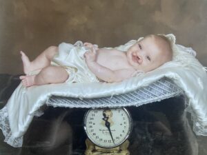 Gracie as a baby lying on a scale