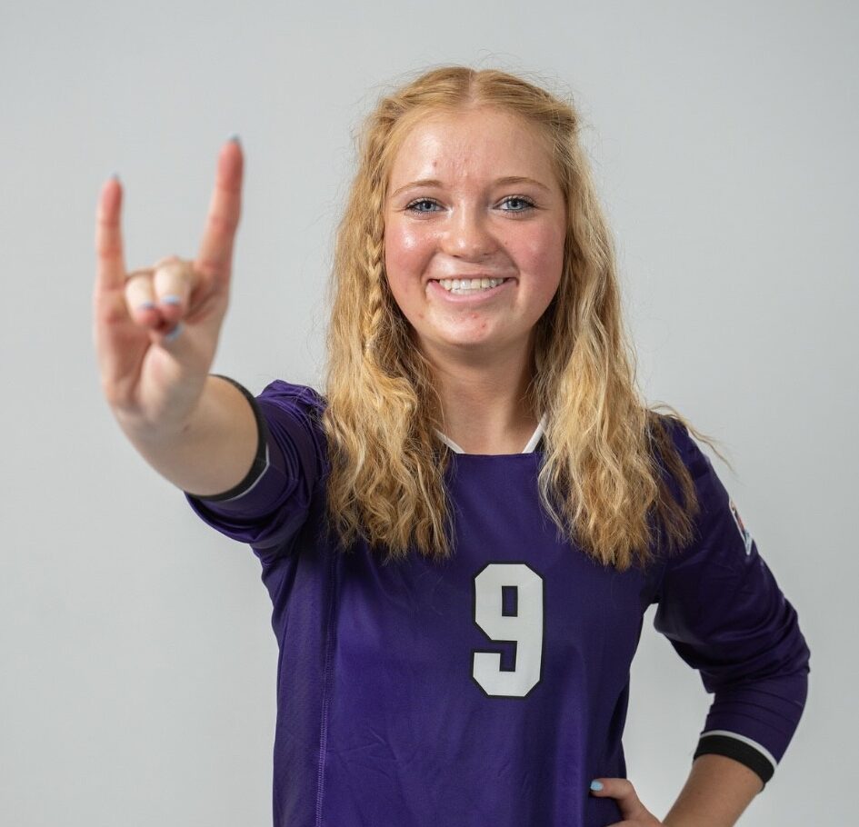 Gracie in her soccer uniform smiling at the camera.