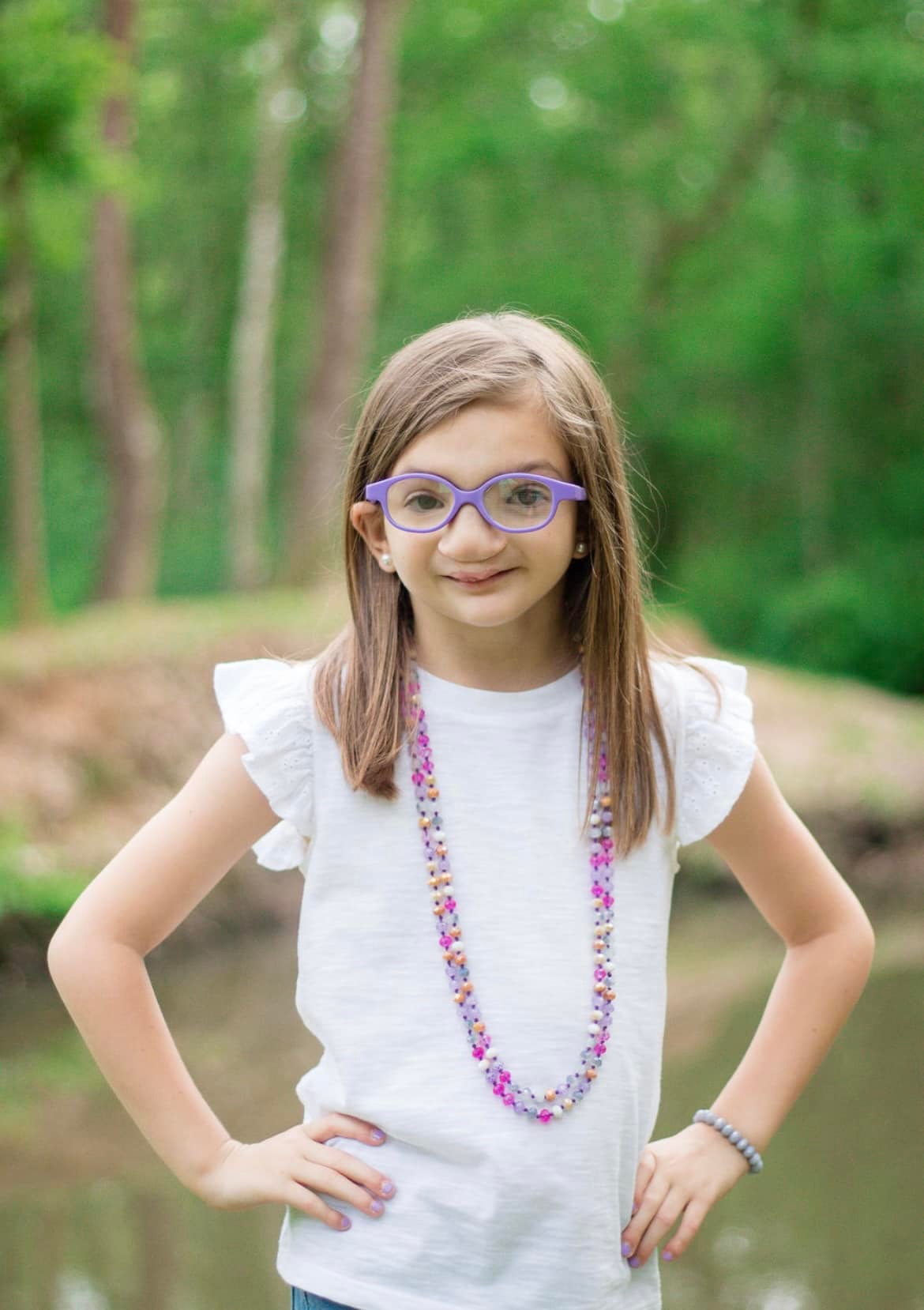 Kynslee is standing with her hands on her hips, smiling at the camera.
