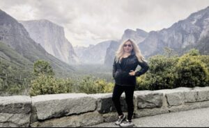 Vanessa standing in front a beautiful mountain landscape.
