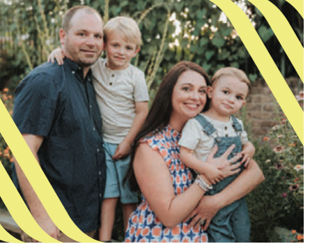 Family of four smiling together