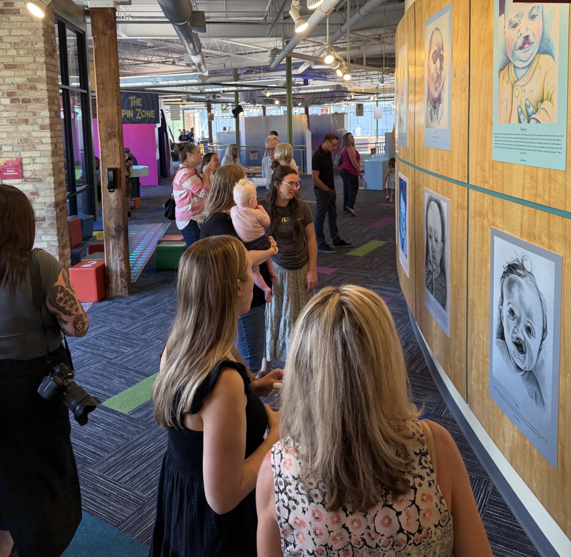 Families mingling and looking at portraits at the Grand Rapids Children's Museum