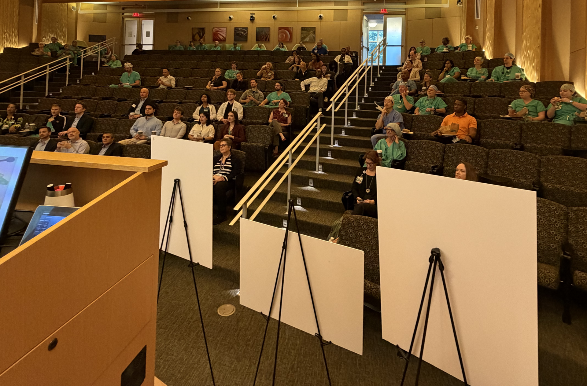 An auditorium shows medical professionals listening to Katie Manning speak at grand rounds at Nemours Children's Hospital in Orlando, FL